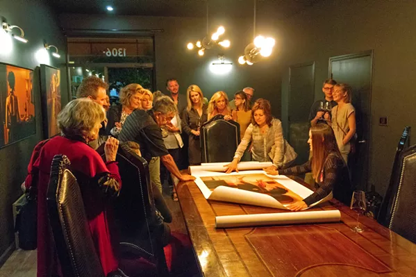 UNVEILING Carrie Graber shows guests prints of her work on the grand table of LXV winery's Library Room. - PHOTOS COURTESY OF ALEX LOPEZ