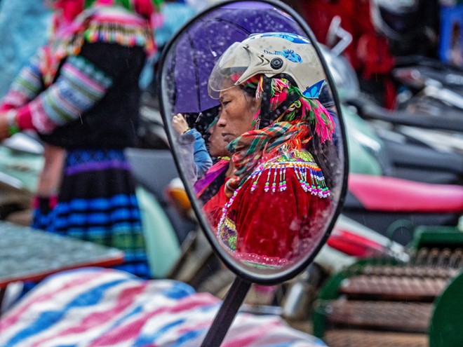 REFLECTIONS Peggy Jansson's Bac Ha Market is a portrait of a Vietnamese woman dressed in traditional clothing reflected in the mirror on her motor bike.