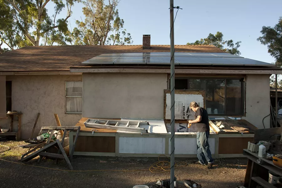 ‘A WORK IN PROGRESS’ : Jim Eickholdt at the Paso Robles home he shares with his wife and daughter. The family must now deal with alleged building code violations after NTF officers called the county building department following a search of the home. - PHOTO BY STEVE E. MILLER