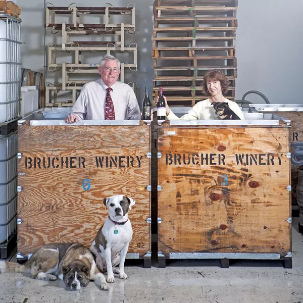 TEAM EFFORT : Mike and Janis Schmidt own and operate the Brucher and Golden Bear wine company in Santa Maria, which help from Gracie (lying down), Pirate, and Dub (in Janis’ arms). - PHOTO BY STEVE E. MILLER