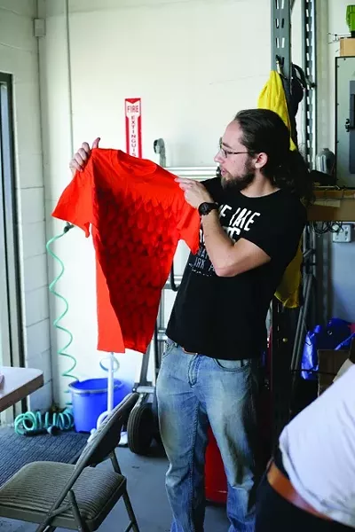 THE HENCHMAN: Argent Data Systems employee Igor Dulkin shows off a T-shirt he decorated using an airbrush. - PHOTO BY GLEN STARKEY