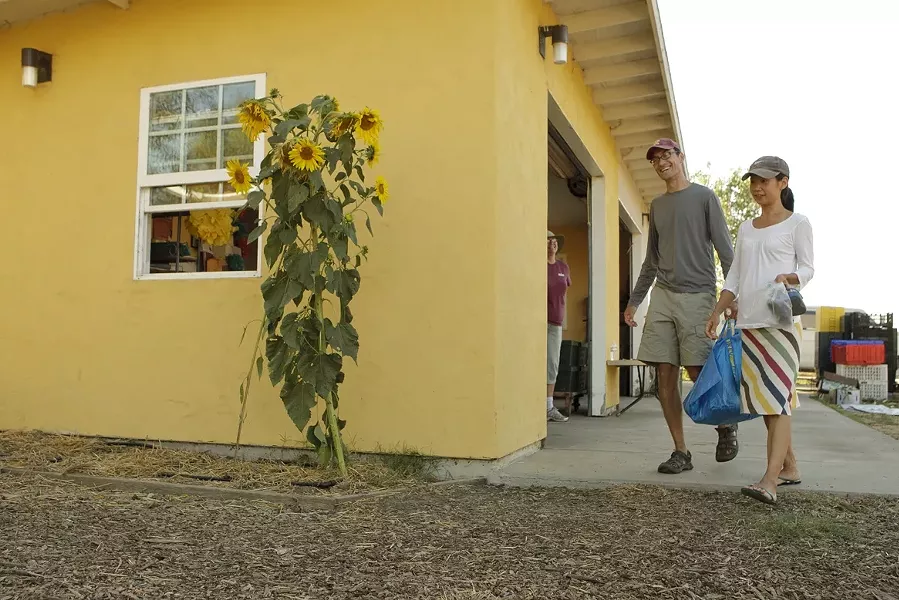ONE LAST BAG : Cal Poly professor Marty Rippens and his wife, longtime subscribers to the Cal Poly Organic Farm CSA program, recently left with their last bag of produce. - PHOTO BY STEVE E. MILLER