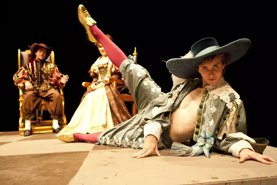 I FEEL PRETTY! : Biscarrat, played by Brandon Howard (foreground), seems to serve no other purpose than to hang out with the King and Queen (Nik Johnson and Fatima Safaverdi, background) while they play cards, but at least he looks good doing it. - PHOTO BY STEVE E. MILLER