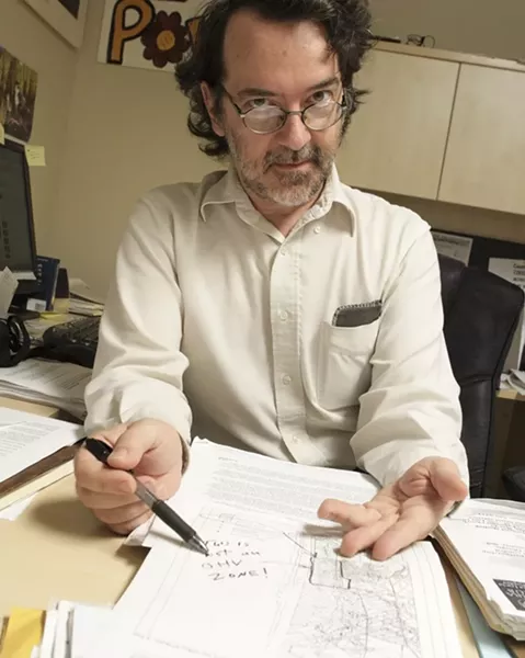 THE CASE OF THE MISSING MAP: The Sierra Club’s Andrew Christie points to the decades-old map, which subsequently went missing from county reports, that spells out plans for a “buffer zone” between off-roaders and natural areas. - PHOTO BY STEVE E. MILLER