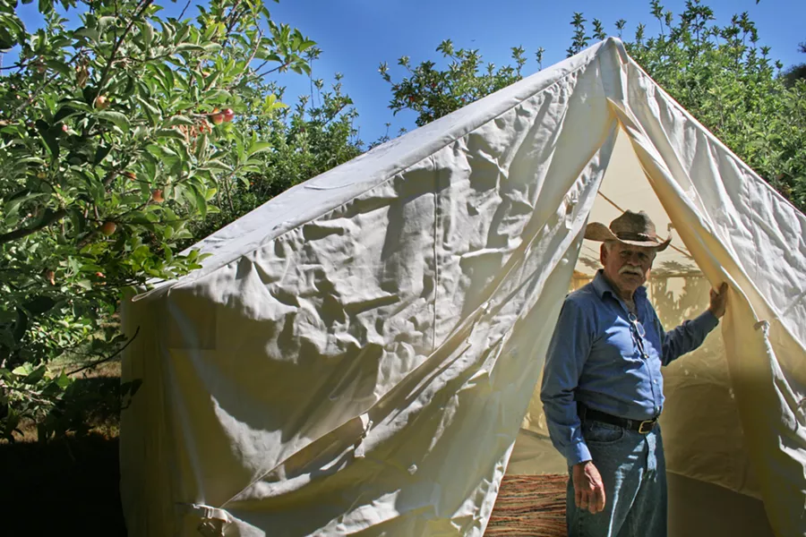CAMP OUT : SLO-based glamping outfitter Whereabout has partnered with FARMstead ED and Windrose Farms to present bohemian-style camping during the farm’s annual Heirloom Tomato Fest slated for Sept 20-21 in Paso Robles. Pictured, Windrose Farm owner Bill Spencer checks out the canvas tent in the days leading up to the celebration of all things big, red, and juicy. - PHOTO BY HAYLEY THOMAS