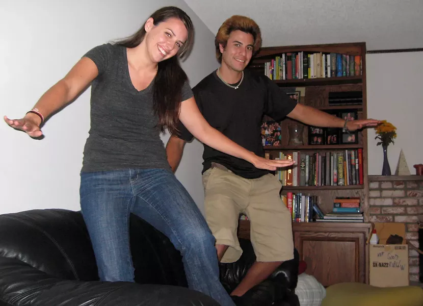 RIDING THE COUCH : Kate Harrison and Nik Goodell barely grumbled when asked to pretend surfing on a couch. Harrison put up her house for the night and Goodell was looking for a place to stay before going back to Santa Cruz - PHOTO BY PATRICK HOWE