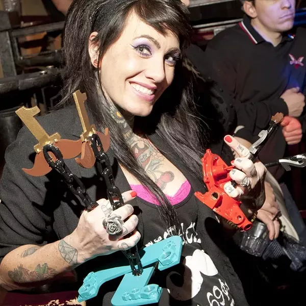 MO SISTA!: The official Movember movement has dubbed the women who help out the cause as Mo Sistas, and here Rosie Bruiser (wife of CCBMC President Mustache Pete) showcases the competition trophies handmade by Sierra Sinner. - PHOTO BY STEVE E. MILLER