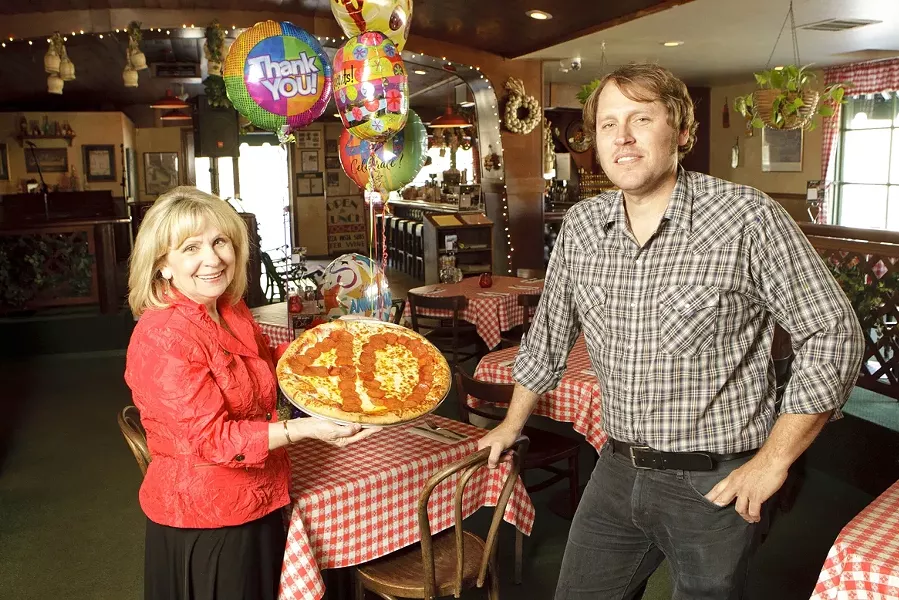 TOP THIS! : Bernadette “Bernie” Donakowski—pictured here with her son Ryan, who manages Del’s—is celebrating 40 years of bringing pizza and other delicious Italian food to the county. - PHOTO BY STEVE E. MILLER