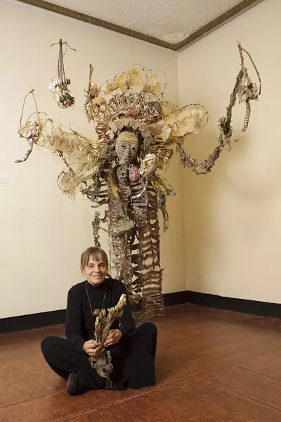 GUARDIAN ANGEL? : Performance artist and sculptor Sha Sha Higby sits at the feet of one of her dazzling creations. Higby’s aesthetic was greatly influenced by a trip to Japan, where she discovered Noh, a 600-year-old tradition of dance theater that, she said, “changed my whole life aspect.” - PHOTOS BY STEVE E. MILLER