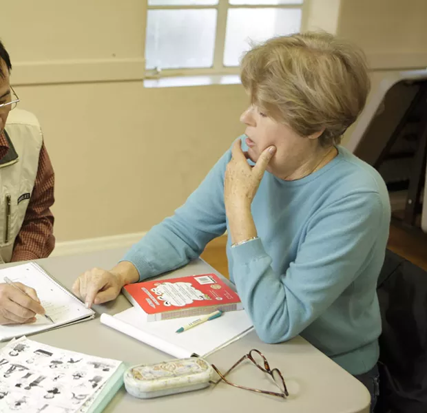 ONE LESSON AT A TIME : Mary Kleeman works with a Chinese student whose lessons are frequently interrupted by his return trips to China. - PHOTO BY STEVE E. MILLER