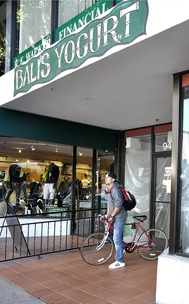 NOT HAPPY : After reading the sign announcing that longtime self serve frozen yogurt shop Bali’s Yogurt had closed, Diego Contreras looked directly across the street, where Yogurtland recently opened in downtown SLO. “I will never go there,” he said. - PHOTO BY CAMILLIA LANHAM
