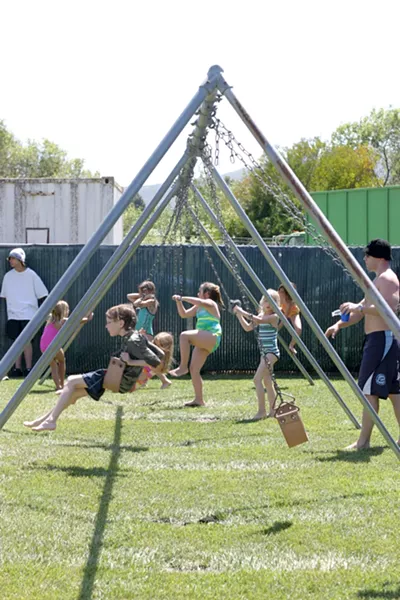 SWINGERS : Kids were everywhere, swinging, climbing, and tumbling through the grassy playground area by the pool. - PHOTO BY GLEN STARKEY