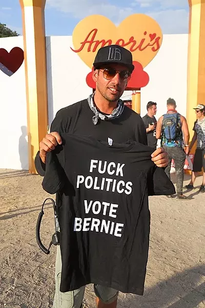 TRANSFORMATIONAL POLITICS: Lightning in a Bottle co-founder Dede Flemming holds up a shirt supporting Bernie Sanders. - PHOTO BY DYLAN HONEA-BAUMANN