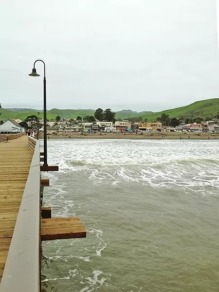 PIER-ING BACK: The view from the end of the Cayucos pier back to shore was magnificent: bright green rolling hills and the funky beach town of Caycuos in the foreground. - PHOTO BY PETER JOHNSON