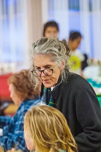 ONE ON ONE: Sharon O’Leary, director for the Community Resource Connections office in Morro Bay, takes time at a community dinner to chat with people who might need help connecting to services. - PHOTO BY JAYSON MELLOM