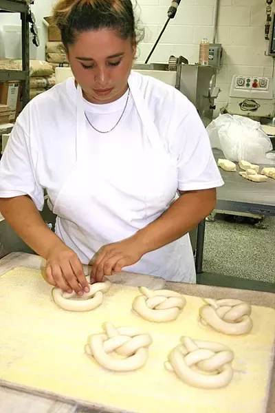 NO STEPS SKIPPED : House of Bagels Central Coast bagelmaker Molly Bueno shapes the eatery’s new pretzels. - PHOTO BY HAYLEY THOMAS