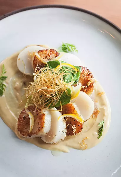 SEA SENSATION Blue Heron's pan seared scallops come with with lemon beurre blanc, crispy leeks, and preserved lemon. - PHOTOS COURTESY OF BLUE HERON