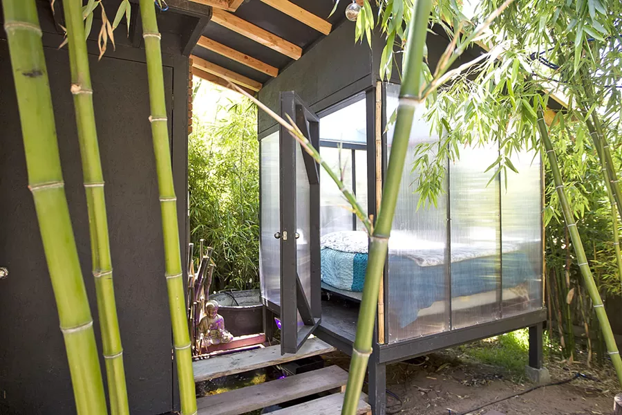 TROPICAL DELIGHT Designer Isaac Horton's Los Osos rental has been made into a lush bamboo-filled forest with a raised outdoor bedroom next to a koi pond and waterfall, with the building constructed with easy-to-disassemble screws. - PHOTO BY JAYSON MELLOM