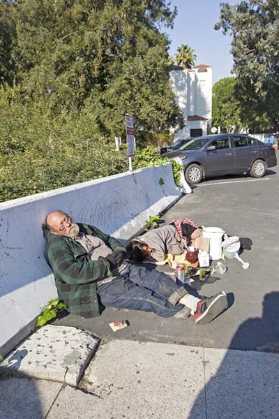 ON THE STREETS Two people sleep in a parking lot in downtown San Luis Obispo. - PHOTO BY JAYSON MELLOM