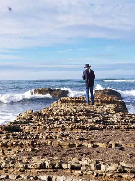TAKING IT IN Sitting on the beach, we saw many people walking toward the edge of the rocks taking photos and selfies of their day. - PHOTO BY KAREN GARCIA