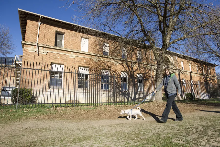 SUPPORT THE PRINTERY Karen McNamara, president of the Atascadero Printery Foundation, walks in front of the printery on Feb. 15. The foundation is holding a fundraiser marathon on March 25 that will help restore the dilapidated building for community use. - PHOTO BY JAYSON MELLOM