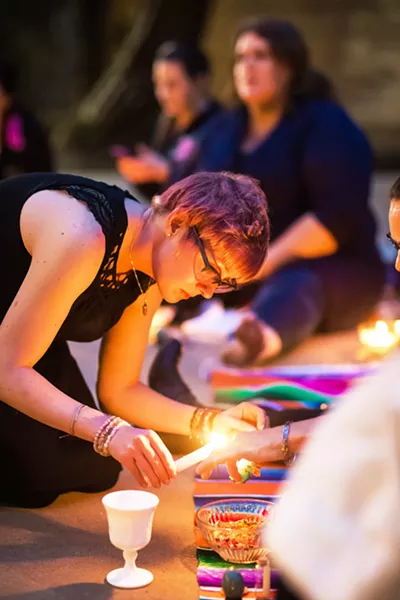 MANIFESTING Women light candles in order to burn intentions written on scraps of paper at a full moon ritual in Arroyo Grande. - PHOTO BY JAYSON MELLOM