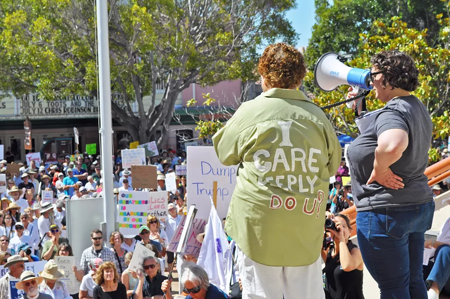 READY TO RALLY Gina Whitaker (left) and Alex Lancaster address a 1,500-strong crowd in front of the SLO County courthouse at a June 30 protest against the separation of undocumented immigrant children from their families by the Trump administration. - PHOTO BY ASHLEY LADIN
