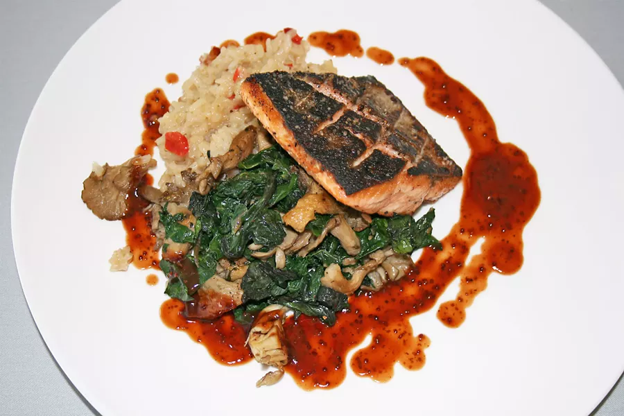 LABOR OF LOVE A portion of wild mushroom rainbow chard offers a tender, earthy bite in contrast with flavorful seared Pacific salmon topped with syrah barbecue sauce. - PHOTO BY HAYLEY THOMAS CAIN