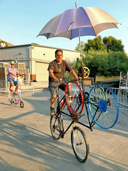 TALL BIKES Bill Mulder (left) and Dan Kallal (right, foreground) ride their custom tall bikes. Kallal's bike won Best Art Bike in the bicycle competition. - PHOTO BY GLEN STARKEY