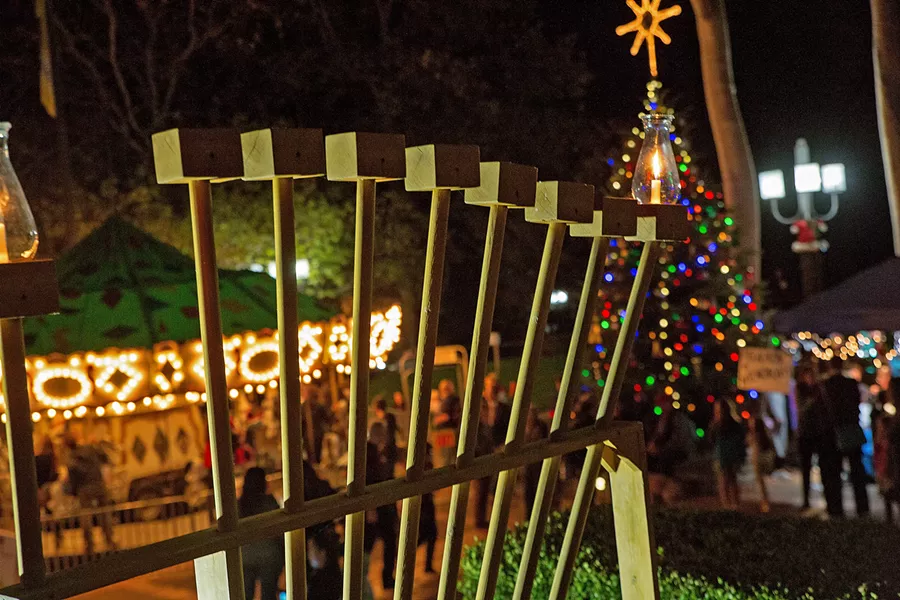 EIGHT NIGHTS OF OIL The first candle on the menorah shines bright in SLO's Mission Plaza in December 2017 on the first night of Hanukkah. - PHOTOS COURTESY OF THE JCC OF SLO
