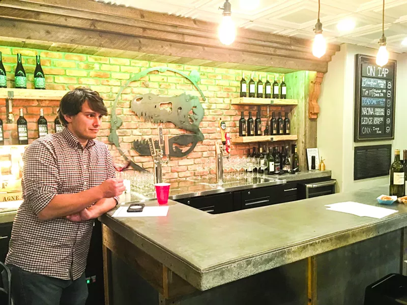 SWIRL TO TASTE Fossil owner Paul Zuniga swirls a pinot noir from Byron Winery in the Santa Maria Valley before he smells it during the Wine 101 class his wine bar hosted in February. - PHOTOS BY CAMILLIA LANHAM