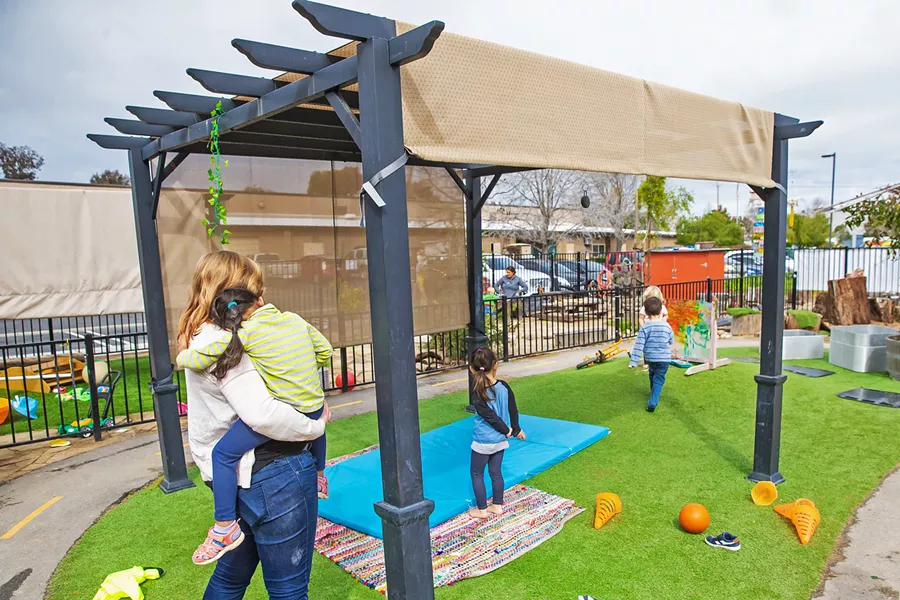 CARE AT WORK Trust Automation owners Ty and Trudie Safreno took child care matters into their own hands by building a preschool for employees just a few hundred feet away from their SLO offices (background). They believe the investment has enabled them to retain many quality workers that they might've otherwise lost. - PHOTOS BY JAYSON MELLOM