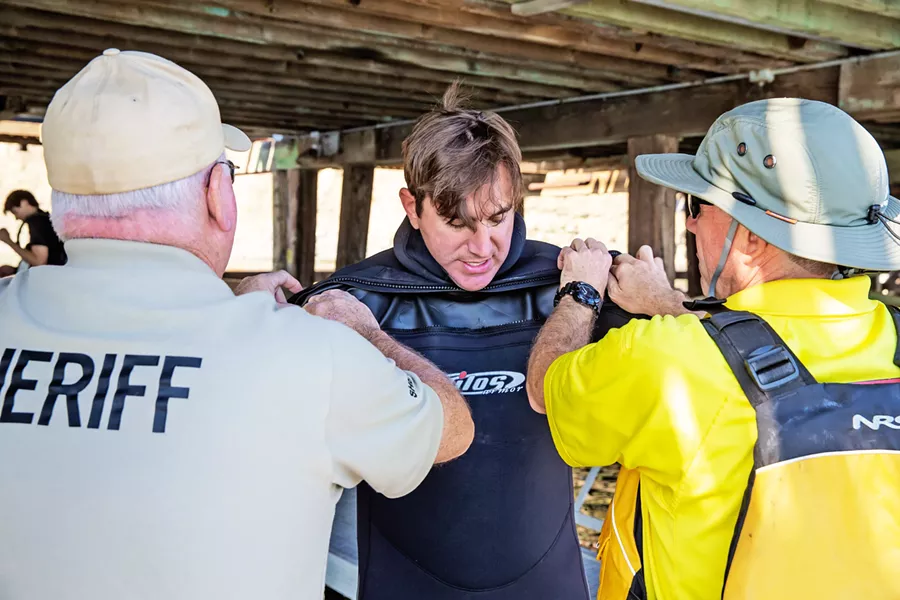 GETTING READY SLO Sheriff's Deputy and dive team member Matthew Shields gets wetsuit help from teammates Pat Nugent (right) and JD Cronin at an Oct. 12 training at Port San Luis. - PHOTO BY JAYSON MELLOM