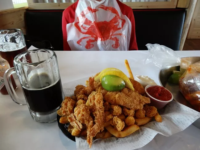 BIBBED FOR HER PLEASURE: Even a restaurant critic wears a lobster bib when tackling the seafood boil and the Cajun mixed seafood and chips. It's a delicious mess of spicy seafood. - PHOTO BY DAN HARDESTY