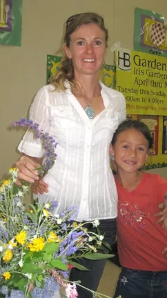 PAGING MRS. GREEN THUMB : Penny Nyunt posed with her two favorite flowers: wooly blue curls and Lilly (her daughter).