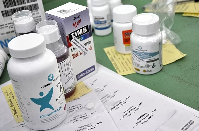 MED CENTRAL: Although most of the medication and vitamins that Waves of Health brings on each mission are donated, the nonprofit spends between $8,000 and $12,000 per trip on medicine that it can’t procure through donations. - PHOTO BY CAMILLIA LANHAM