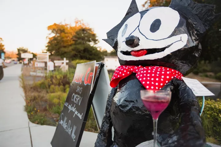 FELIX FELICIS: Felix the Cat, created by Deborah Scarborough, Charlotte Goforth, and Beezie Moore greets guests of the Black Cat Bistro with a message of 'Save Water, Drink Wine.' - PHOTO BY KAORI FUNAHASHI