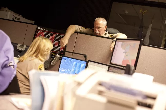 DOWN TIME : Chief Deputy John Giese served as the watch commander on a recent Friday night, when he assisted dispatchers like Kelly Fontes. - PHOTO BY STEVE E. MILLER