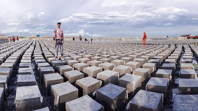 MORE THAN MEETS THE EYE: Concrete blocks are made locally in Bangladesh to reinforce embankments. Husband-and wife-photographer team Eric and Carrie Tomberlin traveled there in the summer of 2014 to see how people there have adapted to climate change. - PHOTO COURTESY OF CARRIE AND ERIC TOMBERLIN