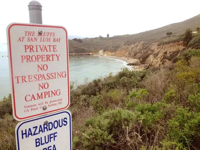 KEEP OUT: The California Coastal Commission sent a stern letter of warning to the city of Pismo Beach over these signs, which they say could discourage public access to the bluffs and trails near Pirate’s Cove. - PHOTO BY CHRIS MCGUINNESS