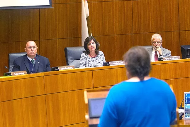 SCOLDED: Los Osos resident Violet Cavanaugh (foreground) criticizes San Luis Obispo County Supervisors John Peschong, Debbie Arnold, and Bruce Gibson (left to right) on March 21 for making a groundwater policy decision on March 7 without public comment. - PHOTO BY JAYSON MELLOM