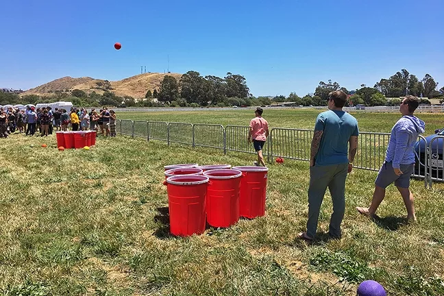 BROS WILL BE BROS: The 2017 California Beer Festival, held May 27 in the Madonna Inn meadow, brought out a huge crowd of college kids, some of whom played giant beer pong. - PHOTO BY GLEN STARKEY