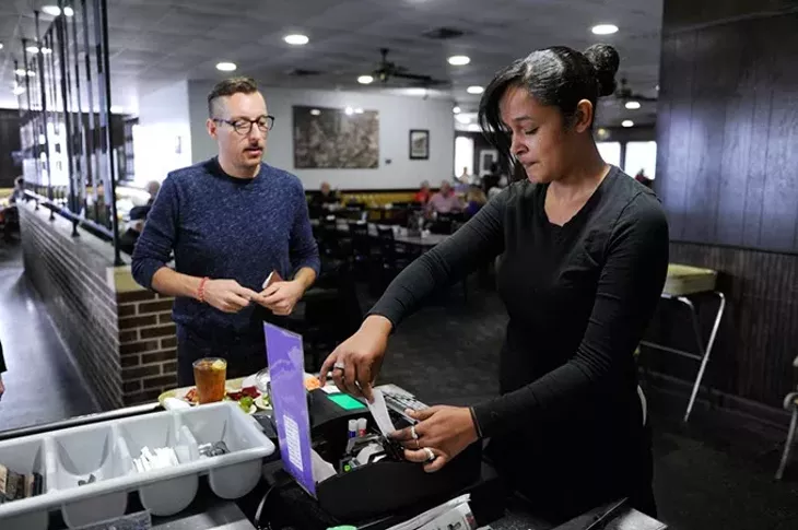 Stacey Jones works the cash register as Lennon Patton buys his food at Boulevard Cafeteria in Oklahoma City, Friday, Dec. 11, 2015. - GARETT FISBECK
