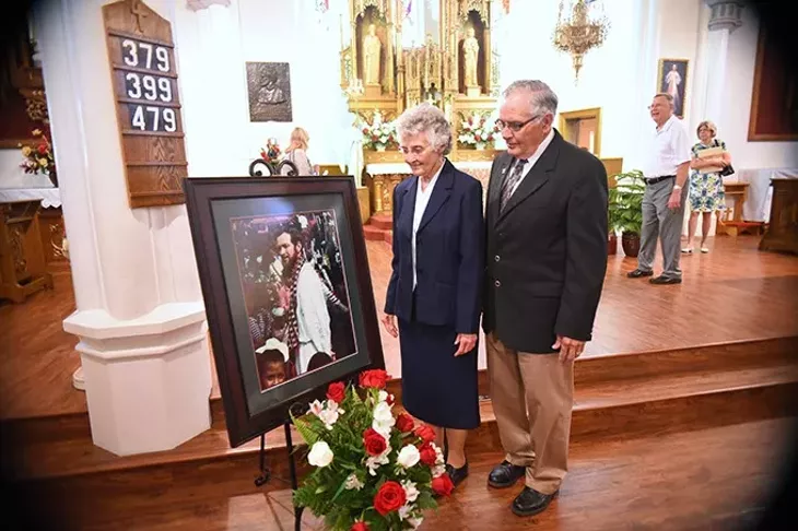 Sister Marita Rother and Tom Rother, siblings of Father Staley Rother with their deceased brothers portrait, after the Anniversary Mass for Father Stanley Rother at the Holy Trinity Catholic Churche in Okarche Oklahoma on Aug. 1. mh