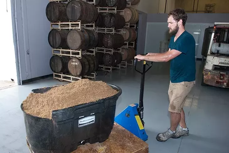 Partner Will Perry transports used mash past the bourbon and whiskey barrels (Mark Hancock)