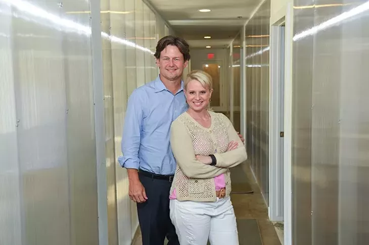 Heather & Keith Paul in a glass hallway at A Good Egg. mh