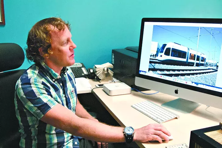 Jeff Bezdek looks at a photo of a Kinkisharyo hybrid streetcar he took at a demo in Dallas. mh