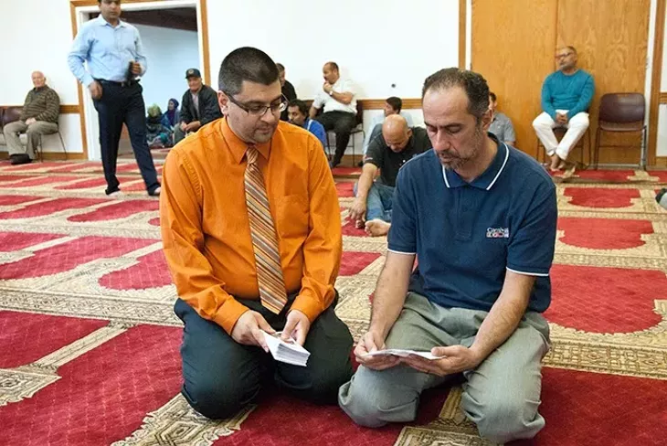 Adam Soltani, CAIR executive director, discusses a pamphlet with a member of the Islamic Society of Oklahoma apon his arrival for the 2:00 prayer service. mh