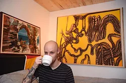 Moore artist, Maurice Perez, sips on coffee in front of his works, (left to right) "Calling" and "Rule of Three", 9-24-15. - MARK HANCOCK