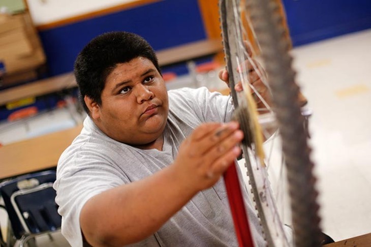 Ruben Cervantes, 16, trues a bicycle wheel at Emerson High School in Oklahoma City, Wednesday, May 6, 2015. - GARETT FISBECK